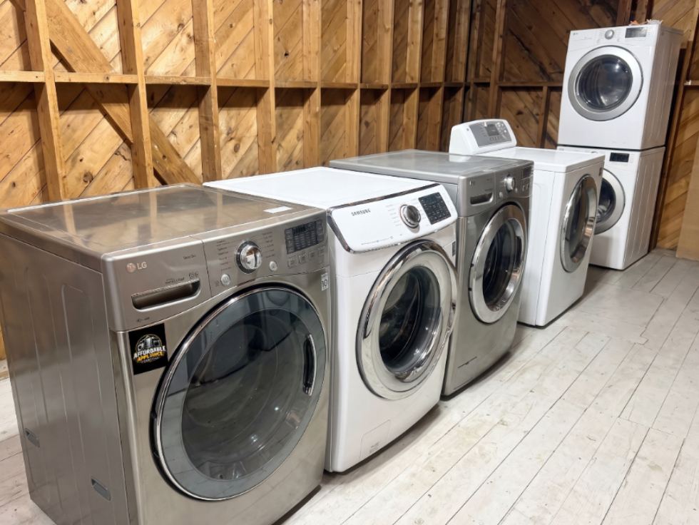 Used stainless steel LG stacked washer and dryer set on the showroom floor at Affordable Appliance