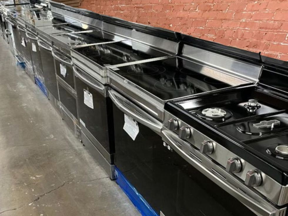 Row of used stainless steel electric ranges and stoves for sale at Affordable Appliance in Klamath Falls